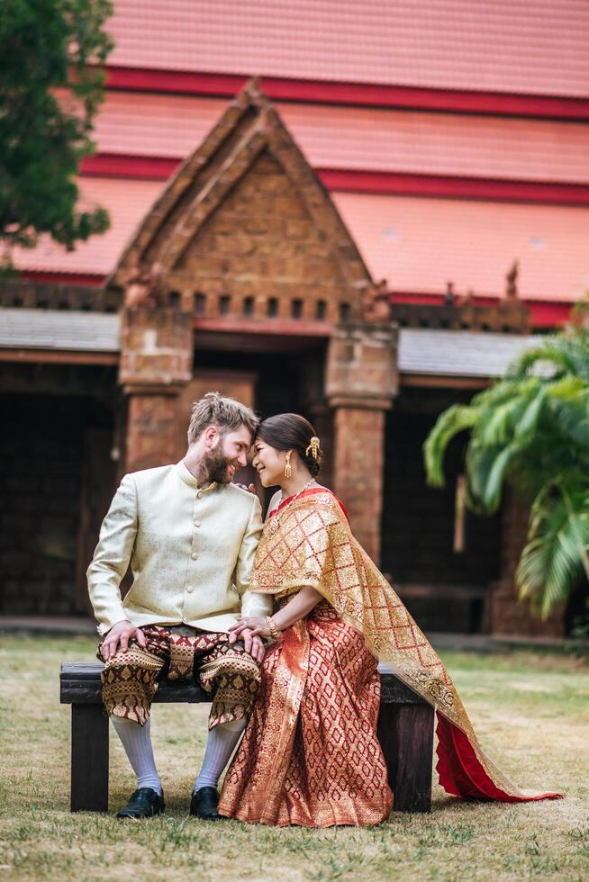 Asian bride and Caucasian groom have romantic time with Thailand dress photo