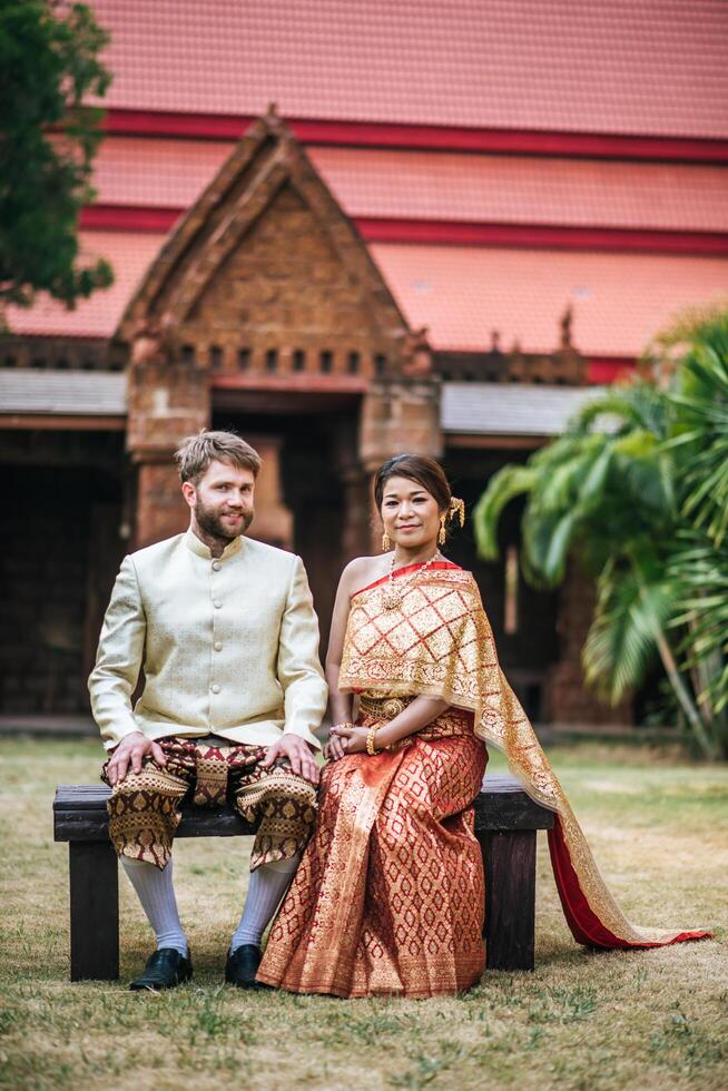 Asian bride and Caucasian groom have romantic time with Thailand dress photo