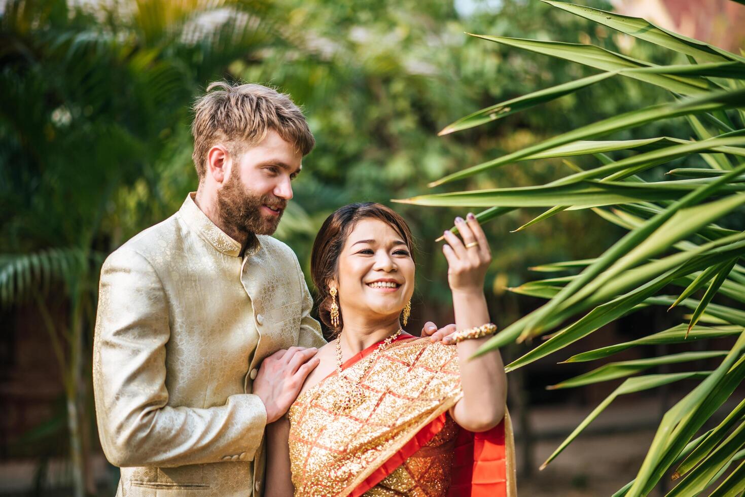 Asian bride and Caucasian groom have romantic time with Thailand dress photo