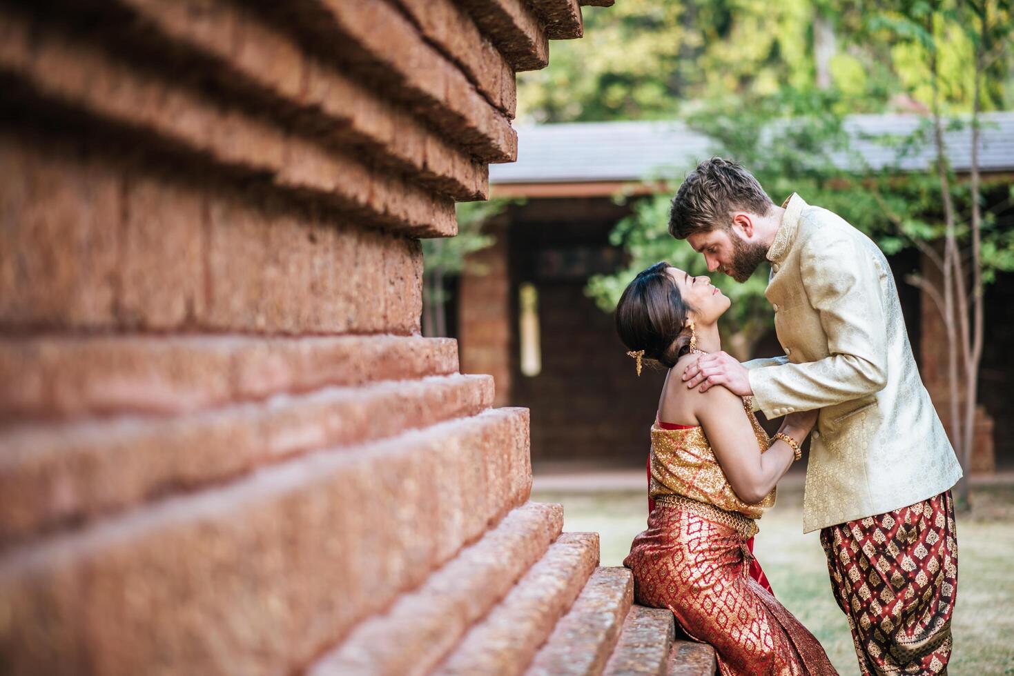 Asian bride and Caucasian groom have romantic time with Thailand dress photo