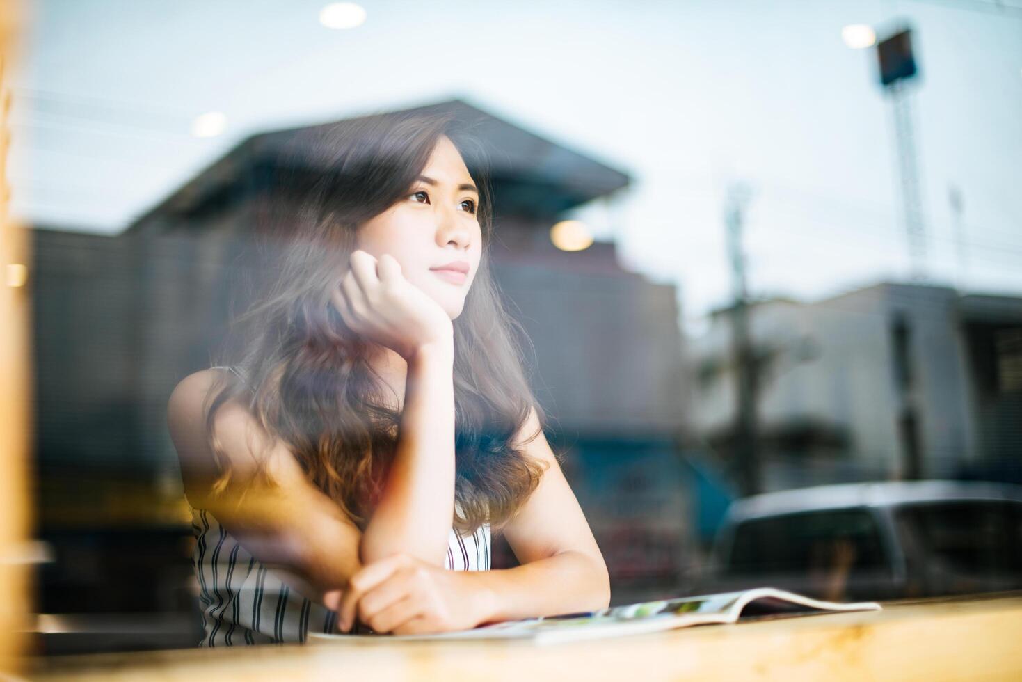 Hermosa mujer leyendo una revista en el café foto