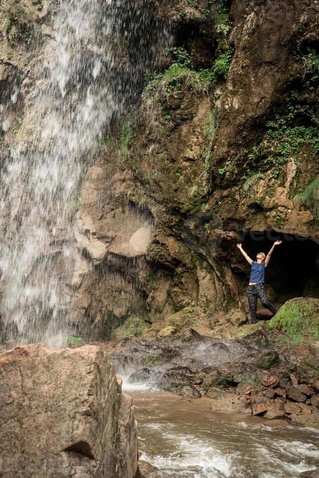 pequeño humano mirando en la hermosa cascada de montaña foto