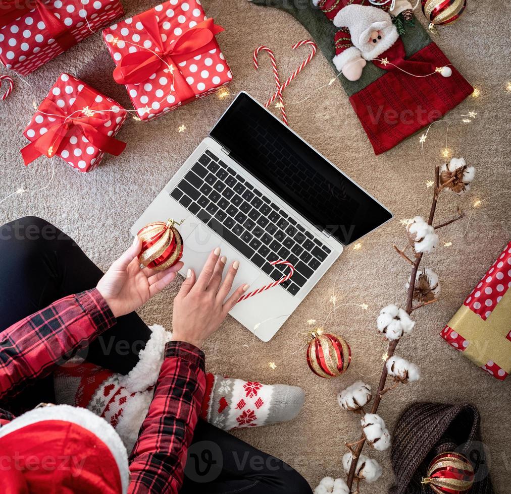 Vista superior de la mujer de compras en línea en las vacaciones de Navidad con un regalo. compras de navidad en línea foto