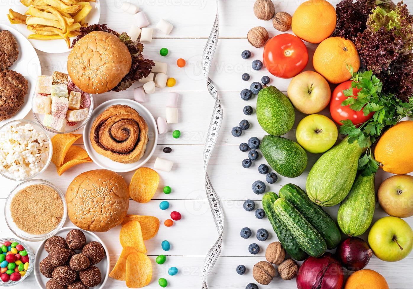 Fruit and vegetables vs sweets and fast food top view flat lay photo