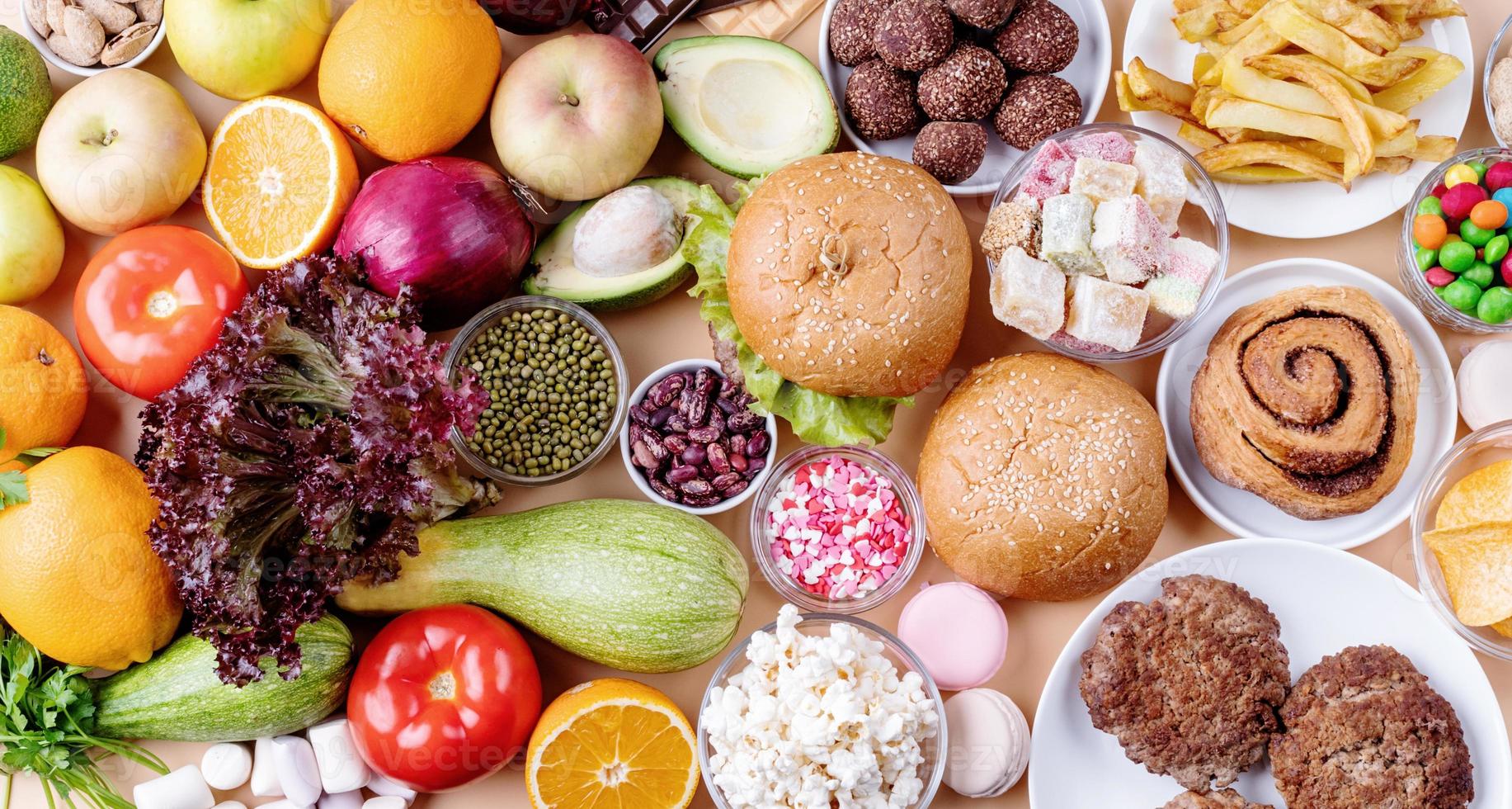 Frutas y verduras vs dulces y comida rápida vista superior plana sobre fondo naranja foto