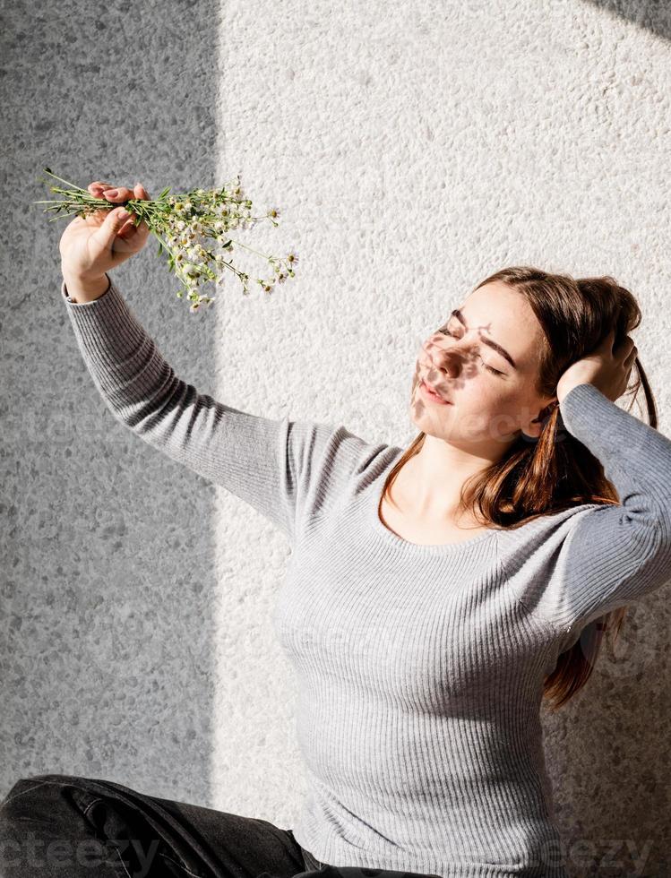 Retrato de una bella mujer joven con un patrón de sombra en la cara y el cuerpo en forma de flores. foto