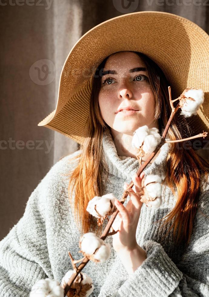 Retrato de una bella mujer joven con un sombrero de paja con un patrón de sombra en la cara y el cuerpo foto