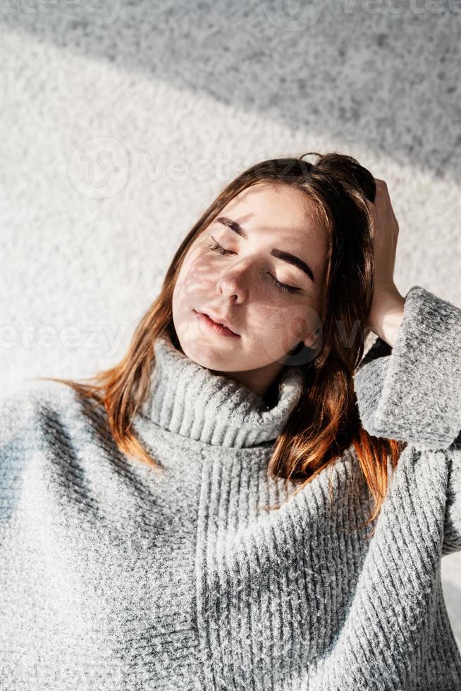 Retrato de una bella mujer joven con un patrón de sombra en la cara y el cuerpo en forma de flores. foto