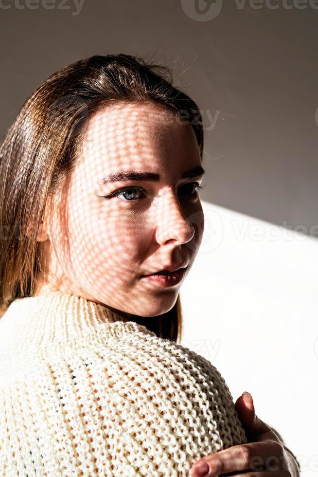 Portrait of a beautiful young woman with a shadow pattern on the face and body photo