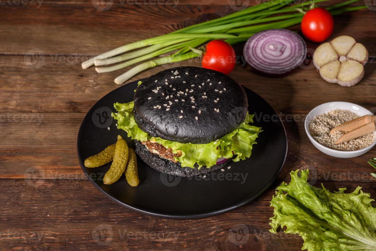 Sabrosa hamburguesa casera a la parrilla con ternera, tomate, queso, pepino y lechuga foto