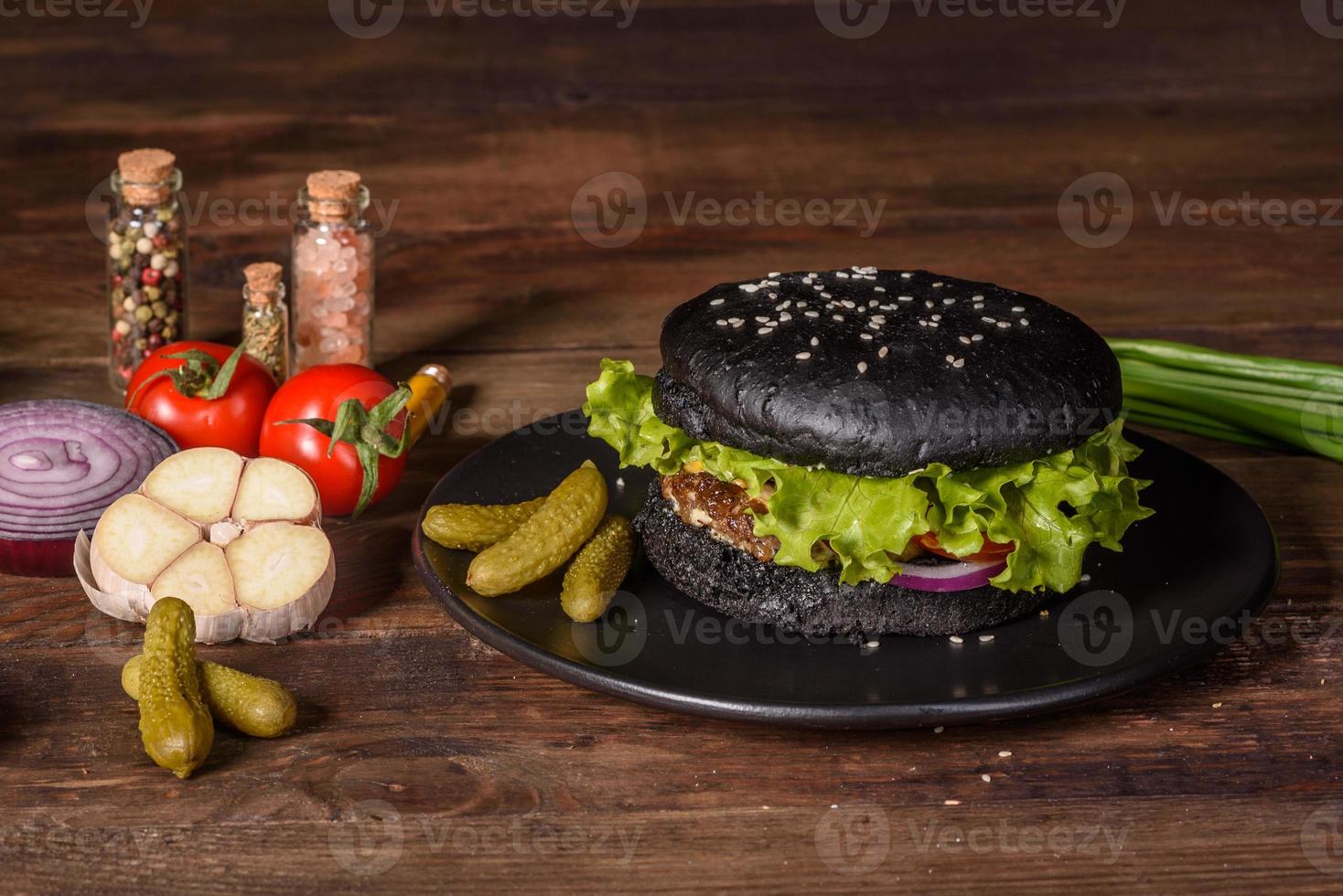 Sabrosa hamburguesa casera a la parrilla con ternera, tomate, queso, pepino y lechuga foto