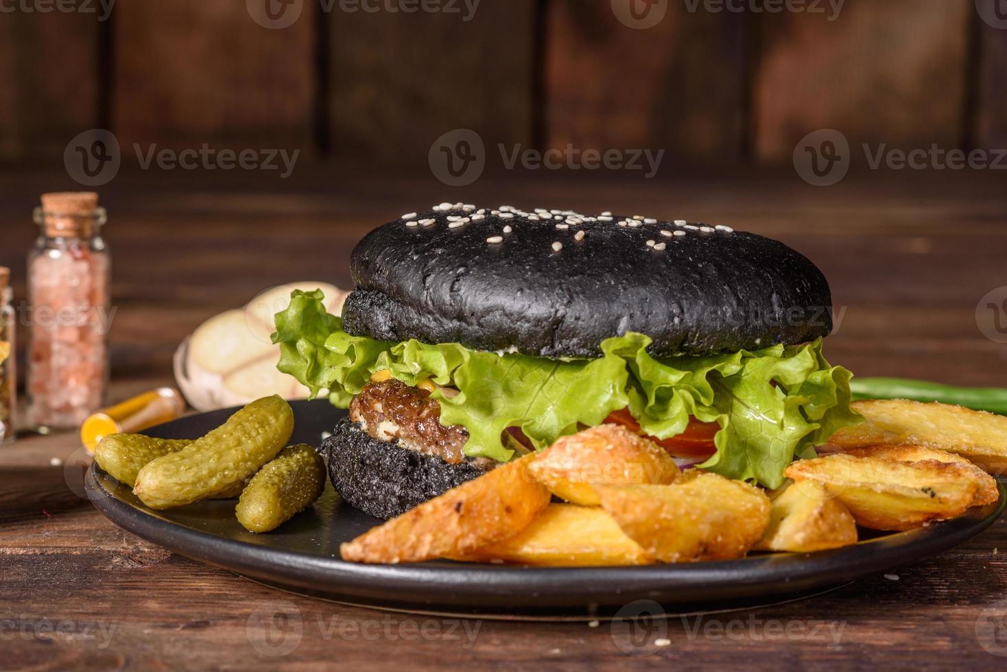 Sabrosa hamburguesa casera a la parrilla con ternera, tomate, queso, pepino y lechuga foto
