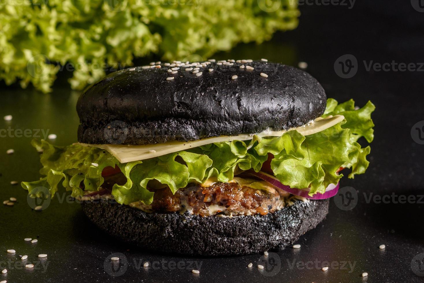 Sabrosa hamburguesa casera a la parrilla con ternera, tomate, queso, pepino y lechuga foto