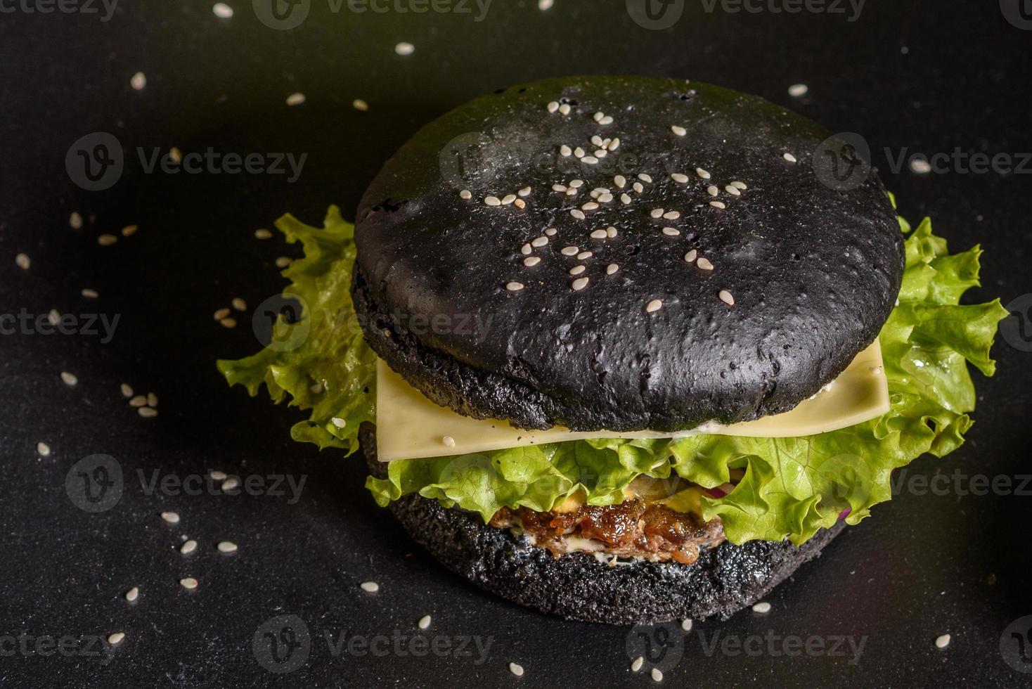 Sabrosa hamburguesa casera a la parrilla con ternera, tomate, queso, pepino y lechuga foto