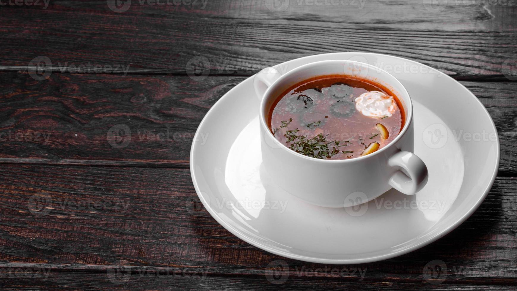 Apetitoso plato de sopa de mezcolanza rusa en olla de cerámica foto