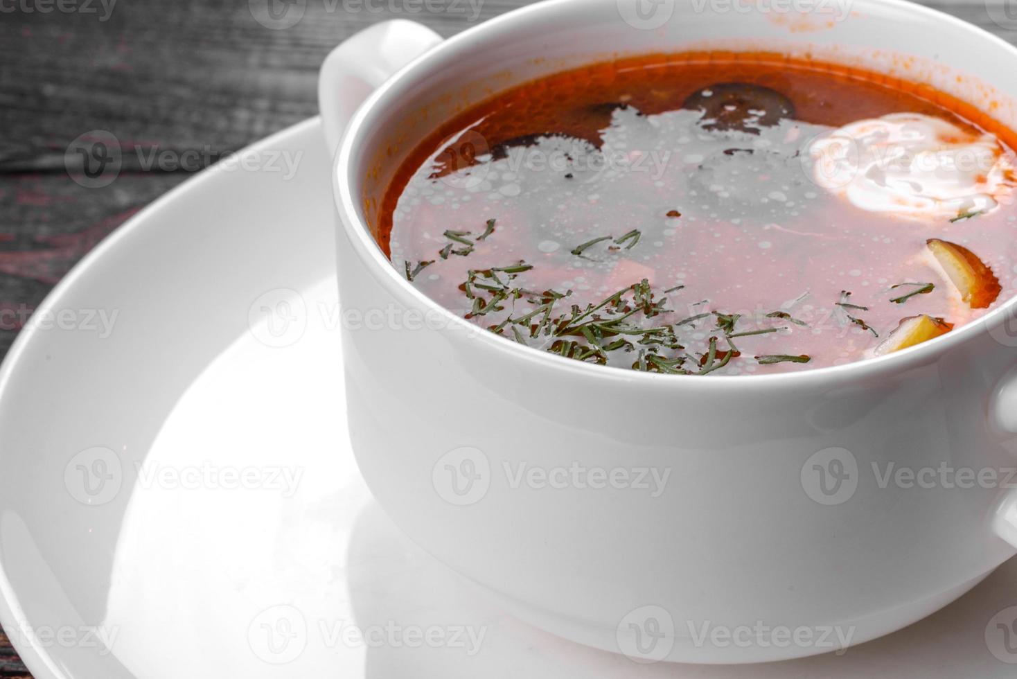 Apetitoso plato de sopa de mezcolanza rusa en olla de cerámica foto