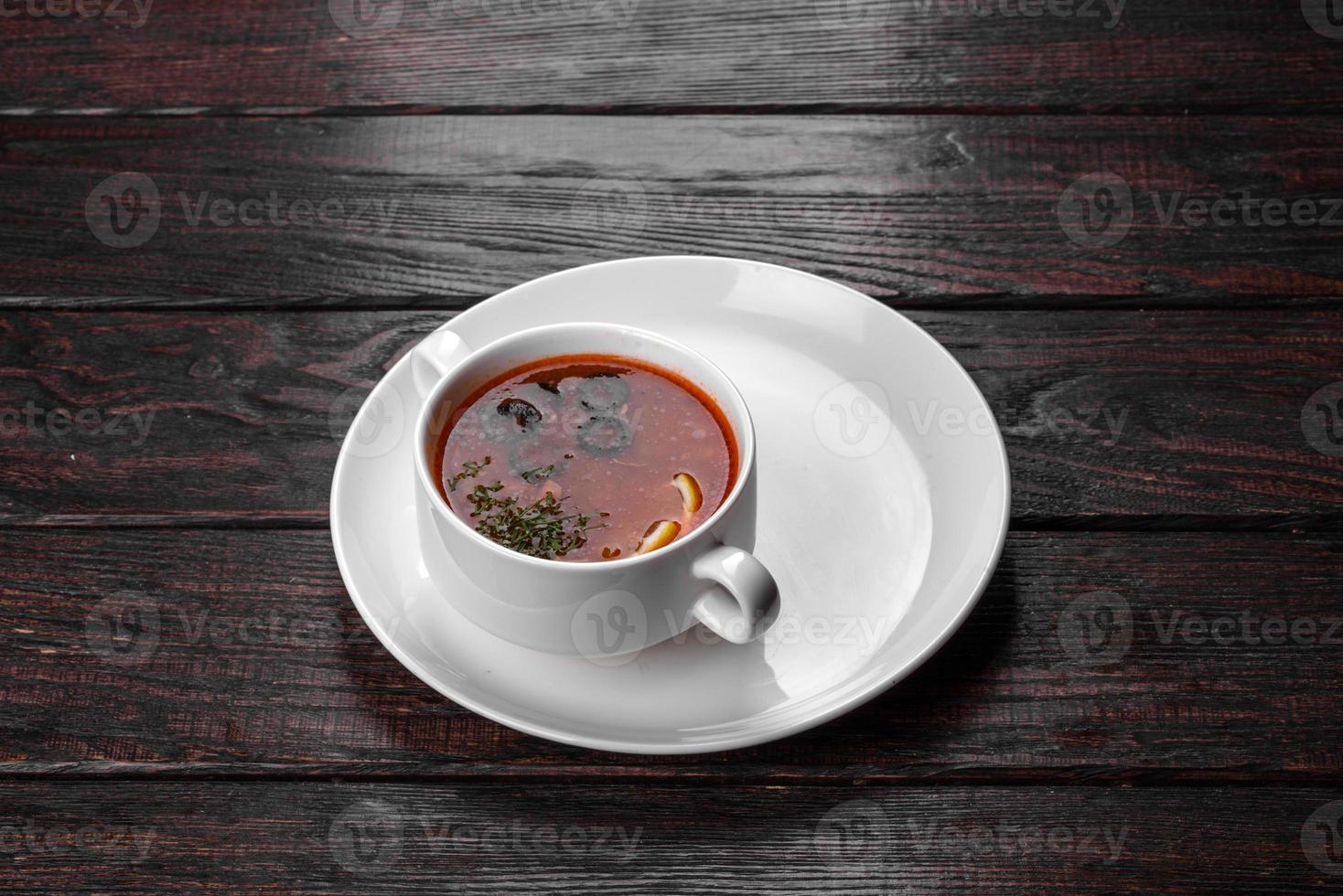Appetizing dish of russian hodgepodge soup in ceramic pot photo