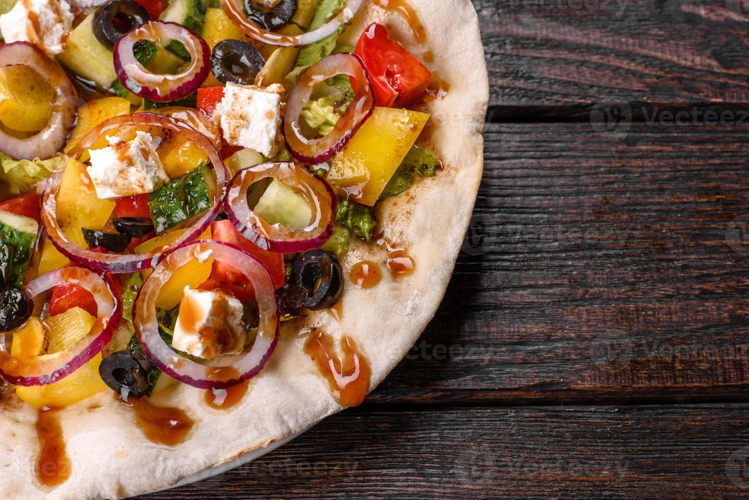 Tasty fresh Greek salad on a pita cooked for a festive table photo