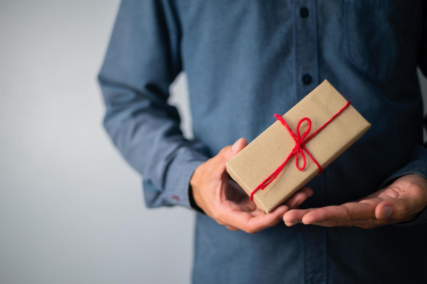 mano que sostiene la caja de regalo, caja de regalo de año nuevo, caja de regalo de Navidad, espacio de copia. Navidad, año nuevo, concepto de cumpleaños. foto