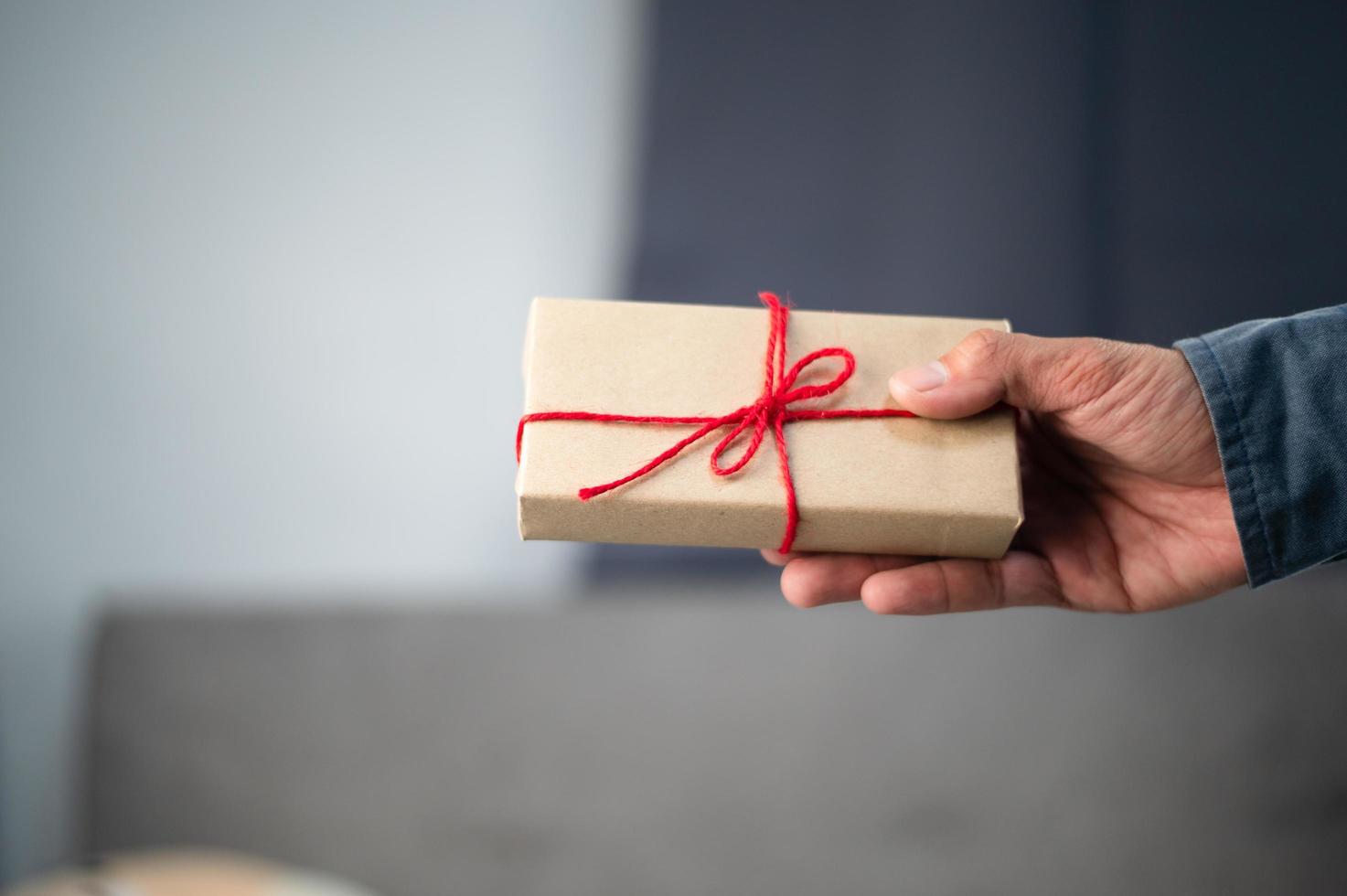 mano que sostiene la caja de regalo, caja de regalo de año nuevo, caja de regalo de Navidad, espacio de copia. Navidad, año nuevo, concepto de cumpleaños. foto