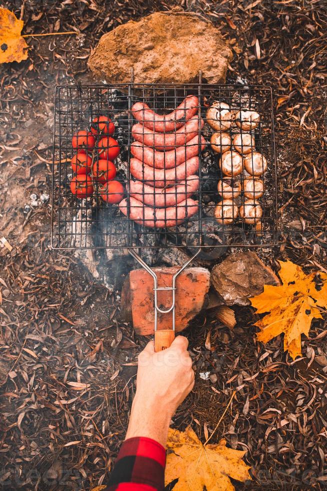 cocinar comida en la hoguera. concepto de camping foto