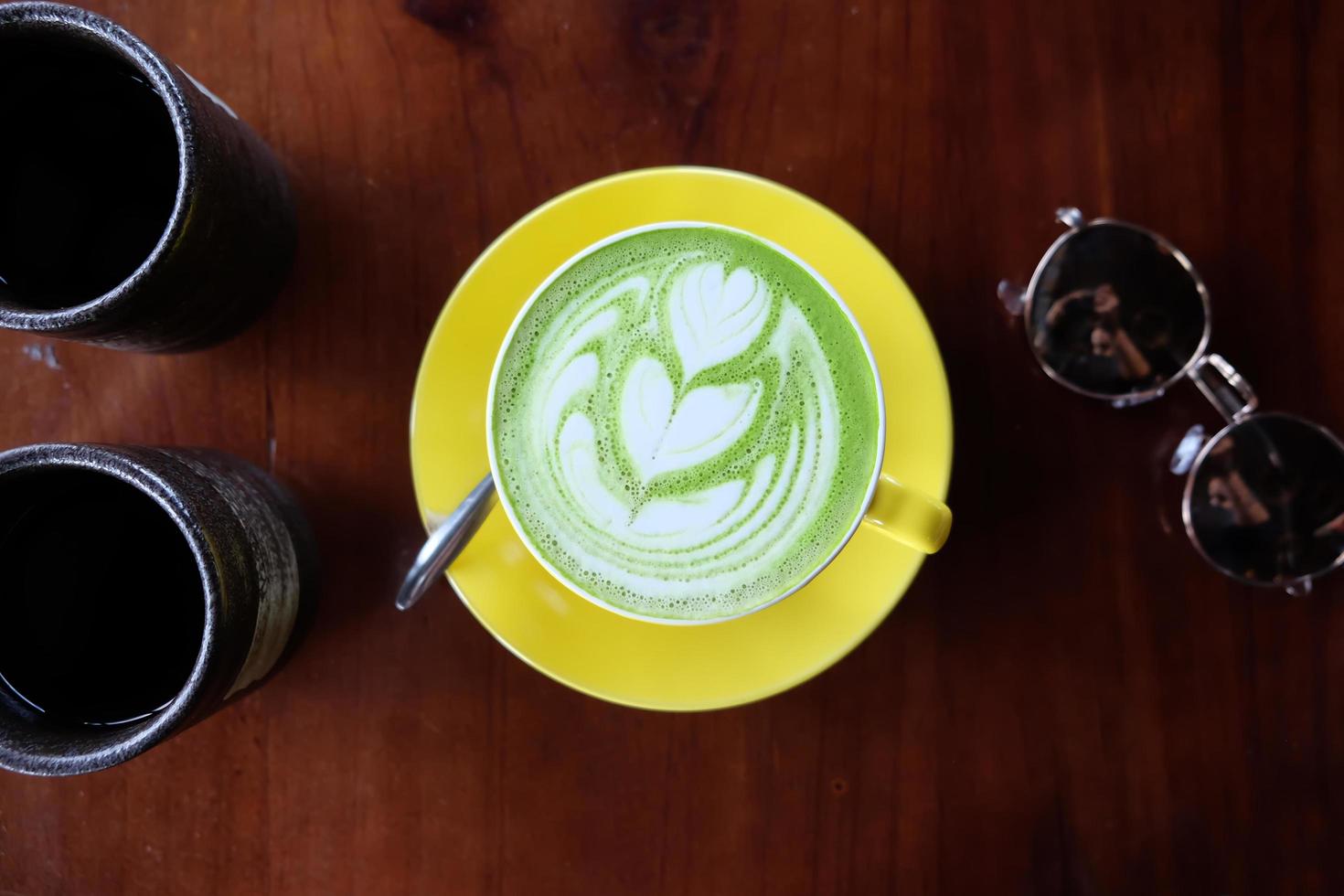 Top view of hot matcha green tea latte art foam photo