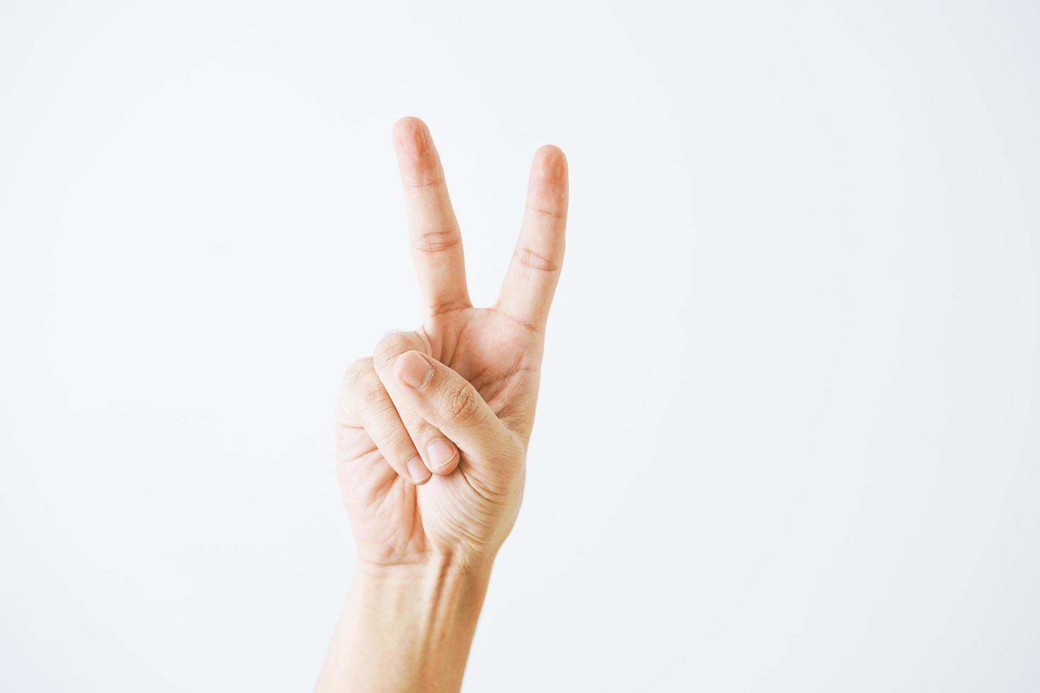 Man hand victory sign gesture on white background. Hand shows the number two photo