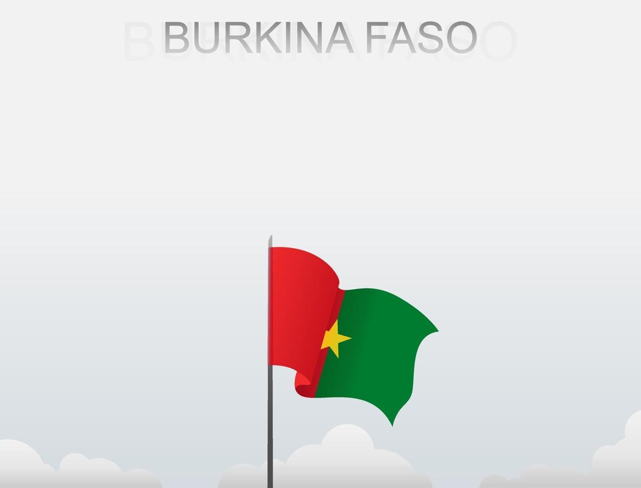 la bandera de burkina faso ondea en un poste alto bajo el cielo blanco vector