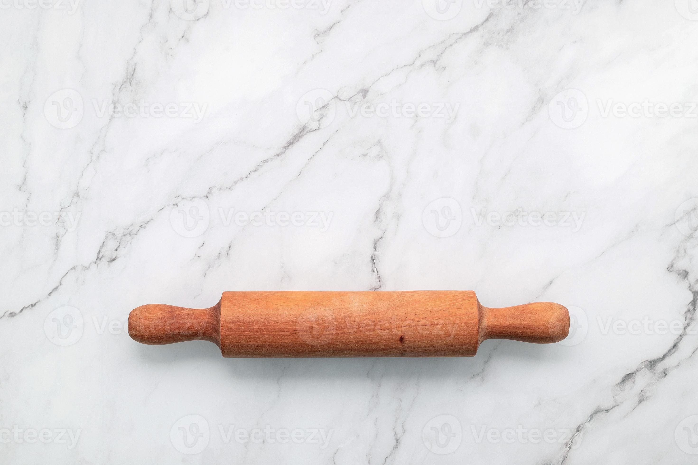 The rolling pin set up on white marble background. Baking background