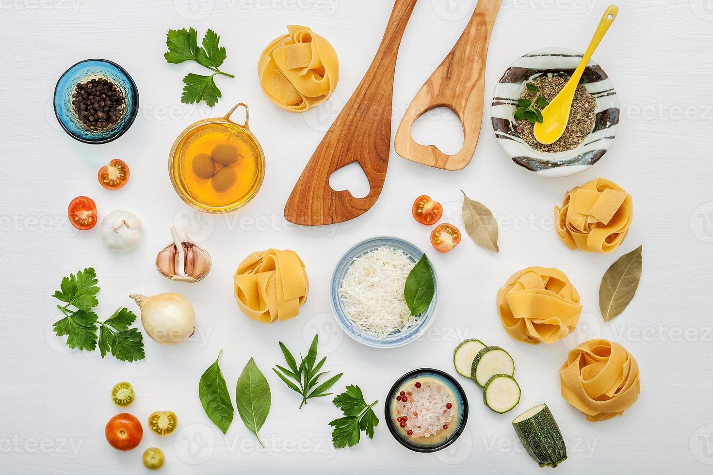 concepto de comida italiana y diseño de menú. Diversos tipos de pasta con espátula de madera sobre fondo blanco de madera con plano. foto