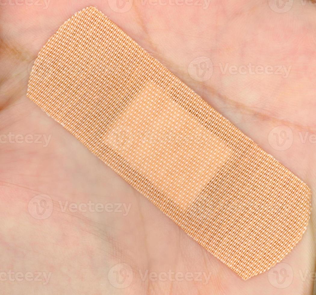 A medical self adhesive bandage on hand photo