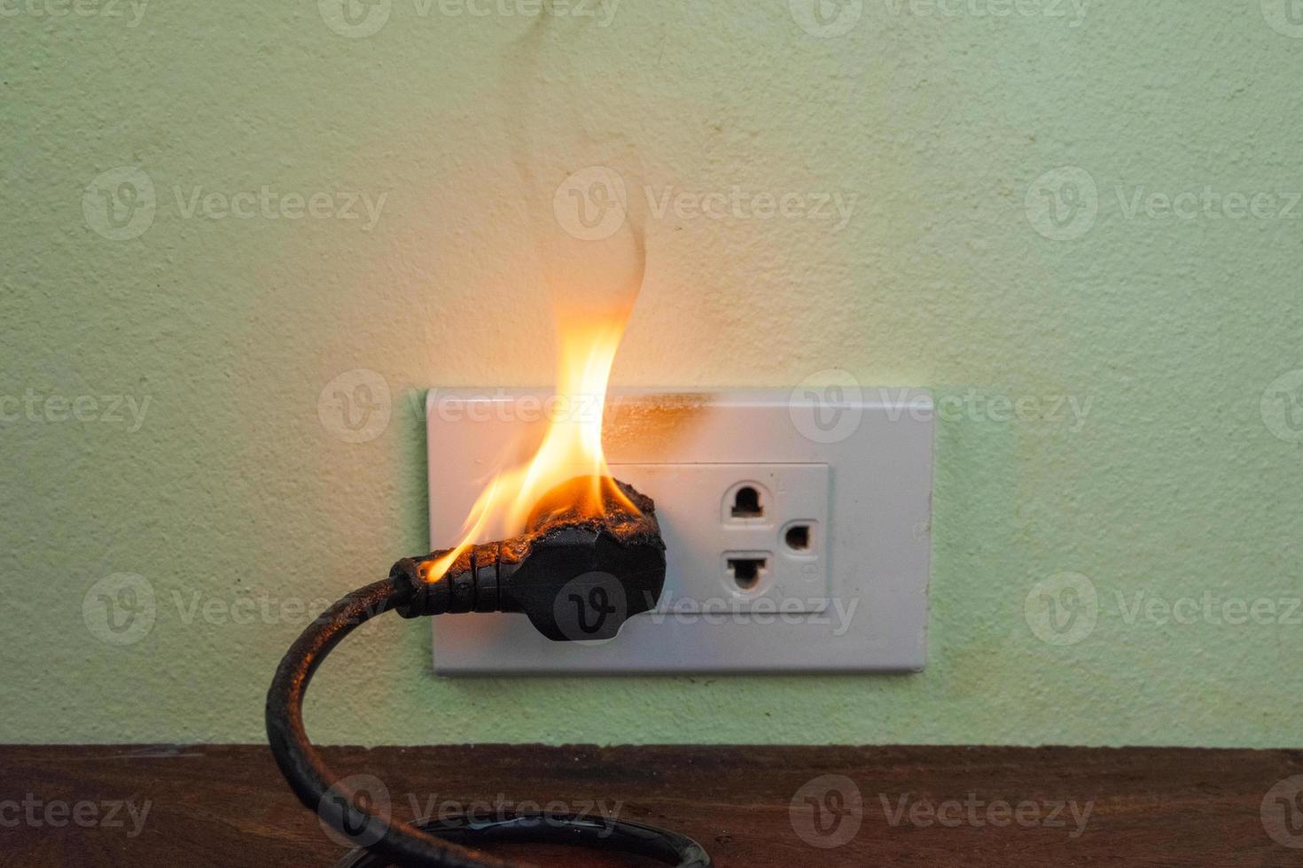 en la pared del receptáculo del enchufe del cable eléctrico del fuego foto