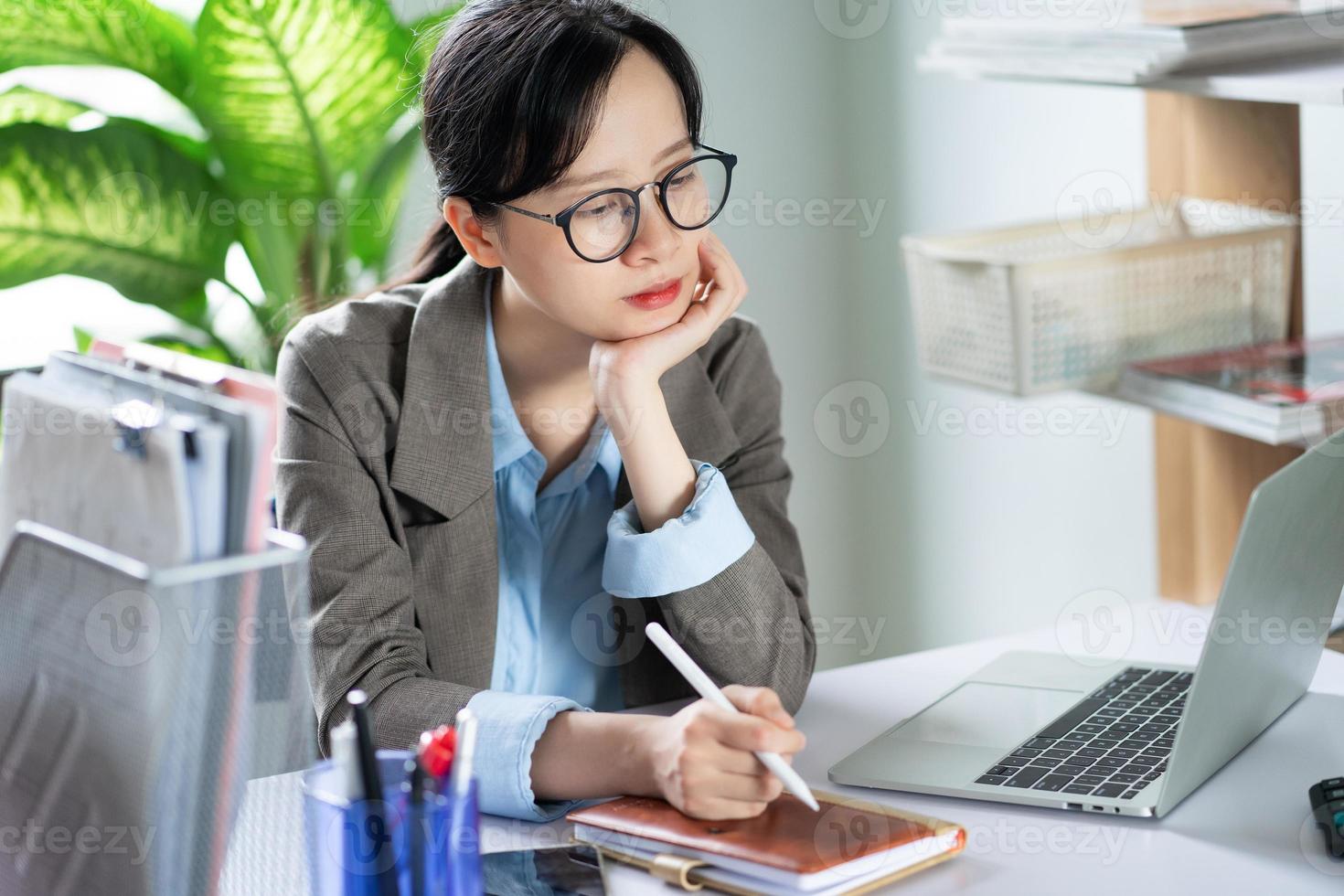 mujer de negocios asiática trabajando desde casa foto