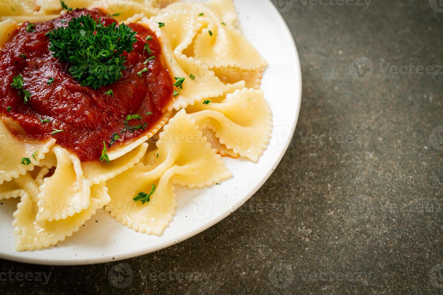 farfalle pasta in tomato sauce with parsley photo