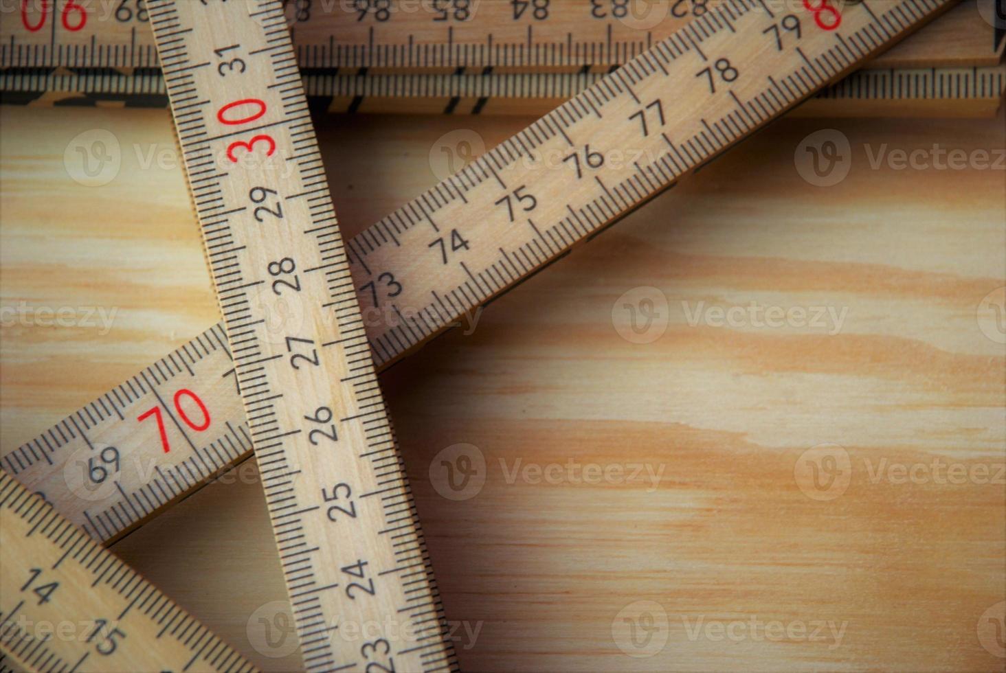 wooden ruler folded several times on a wood background photo