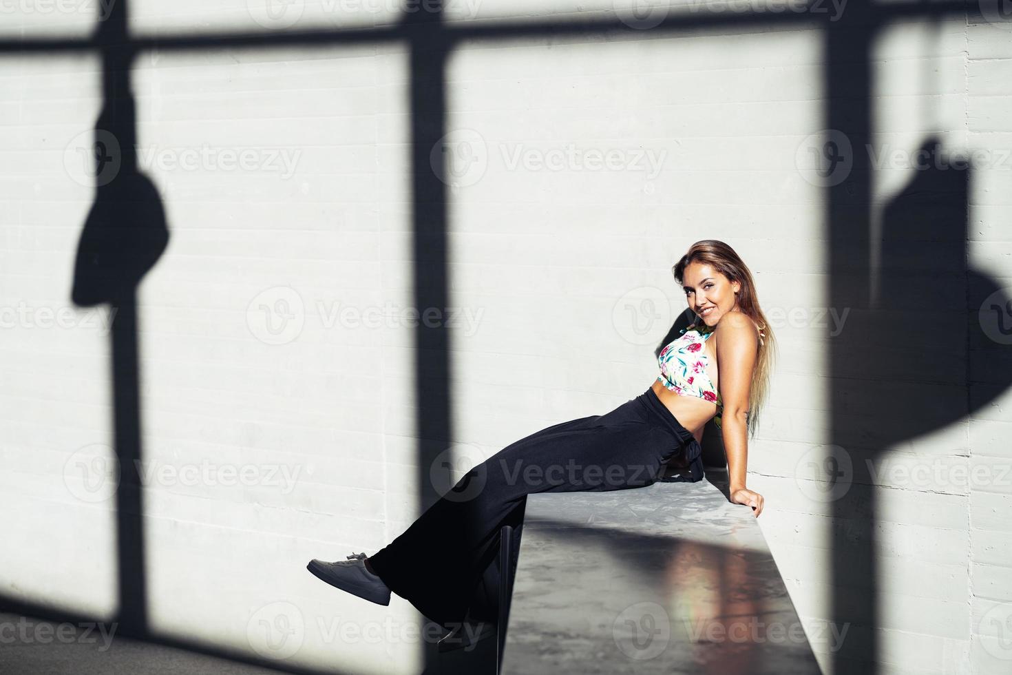 Funny young girl sitting on urban wall photo