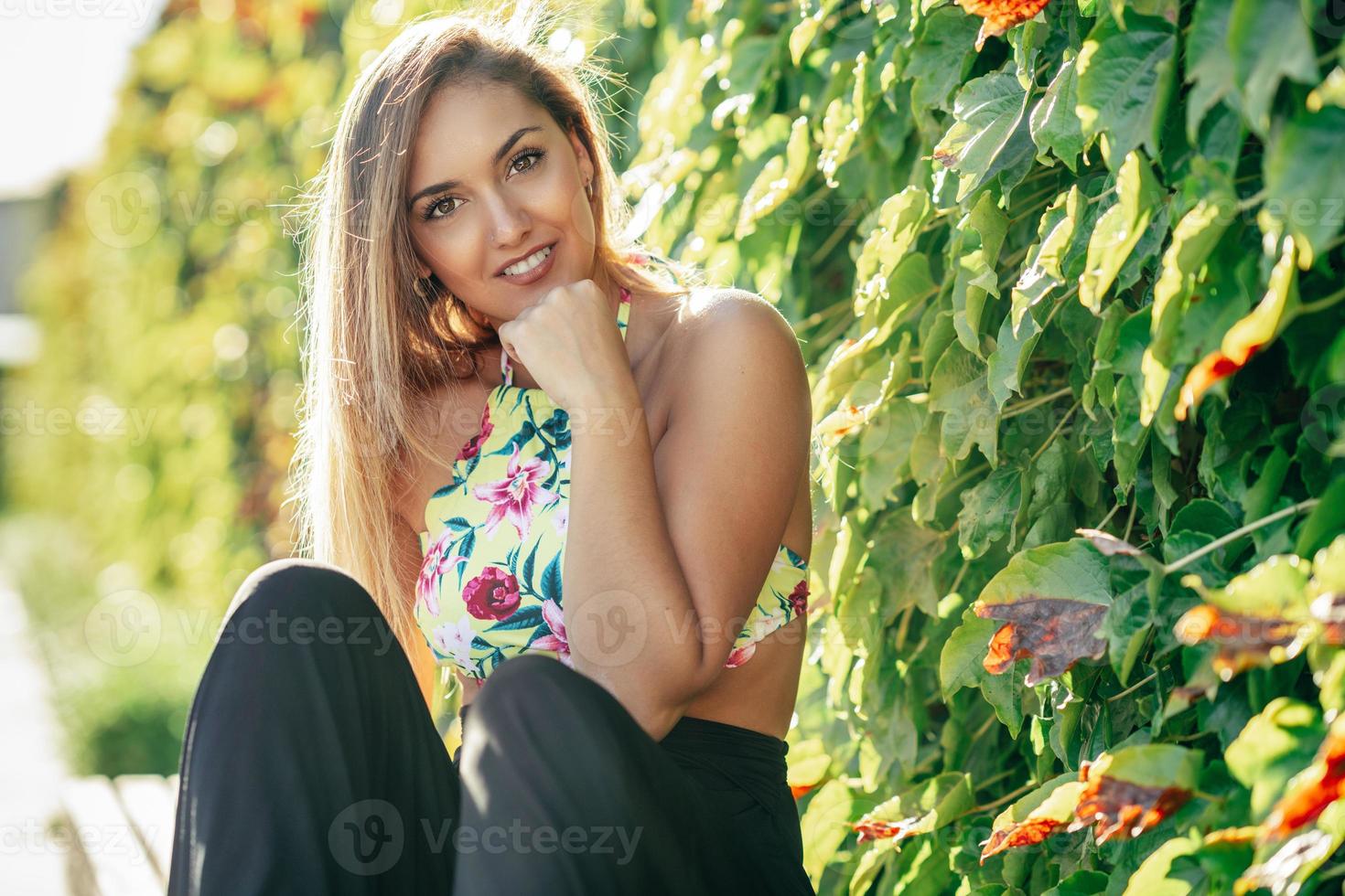 Pretty young girl sitting on urban bench photo