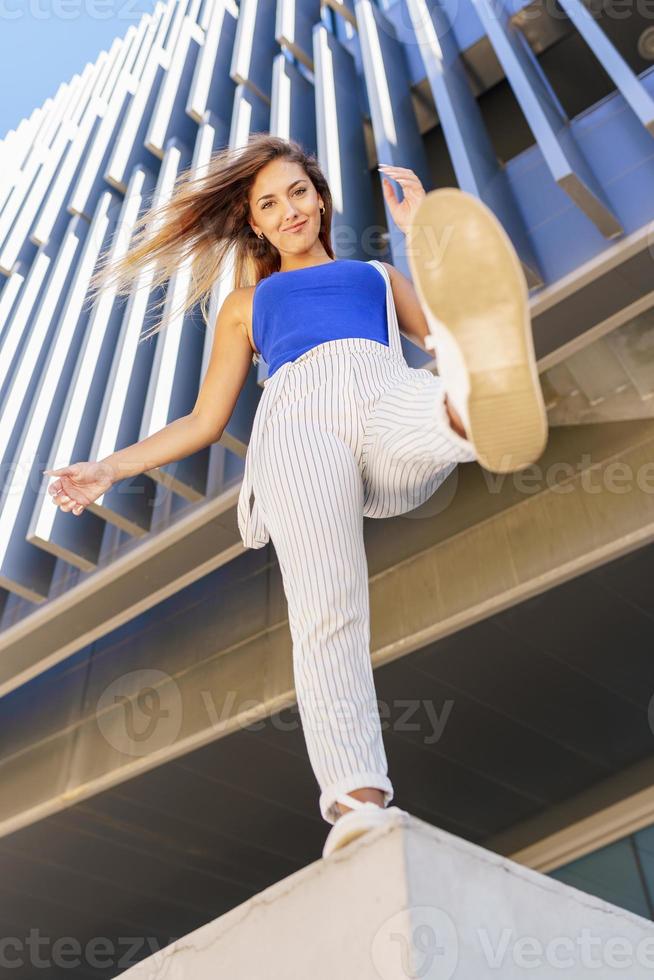 View from below of young girl throwing her foot in the air. photo