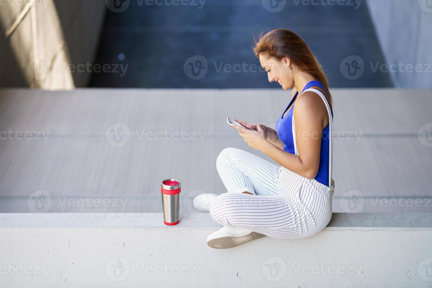 niña usando un teléfono inteligente con pantalla táctil con ropa casual foto