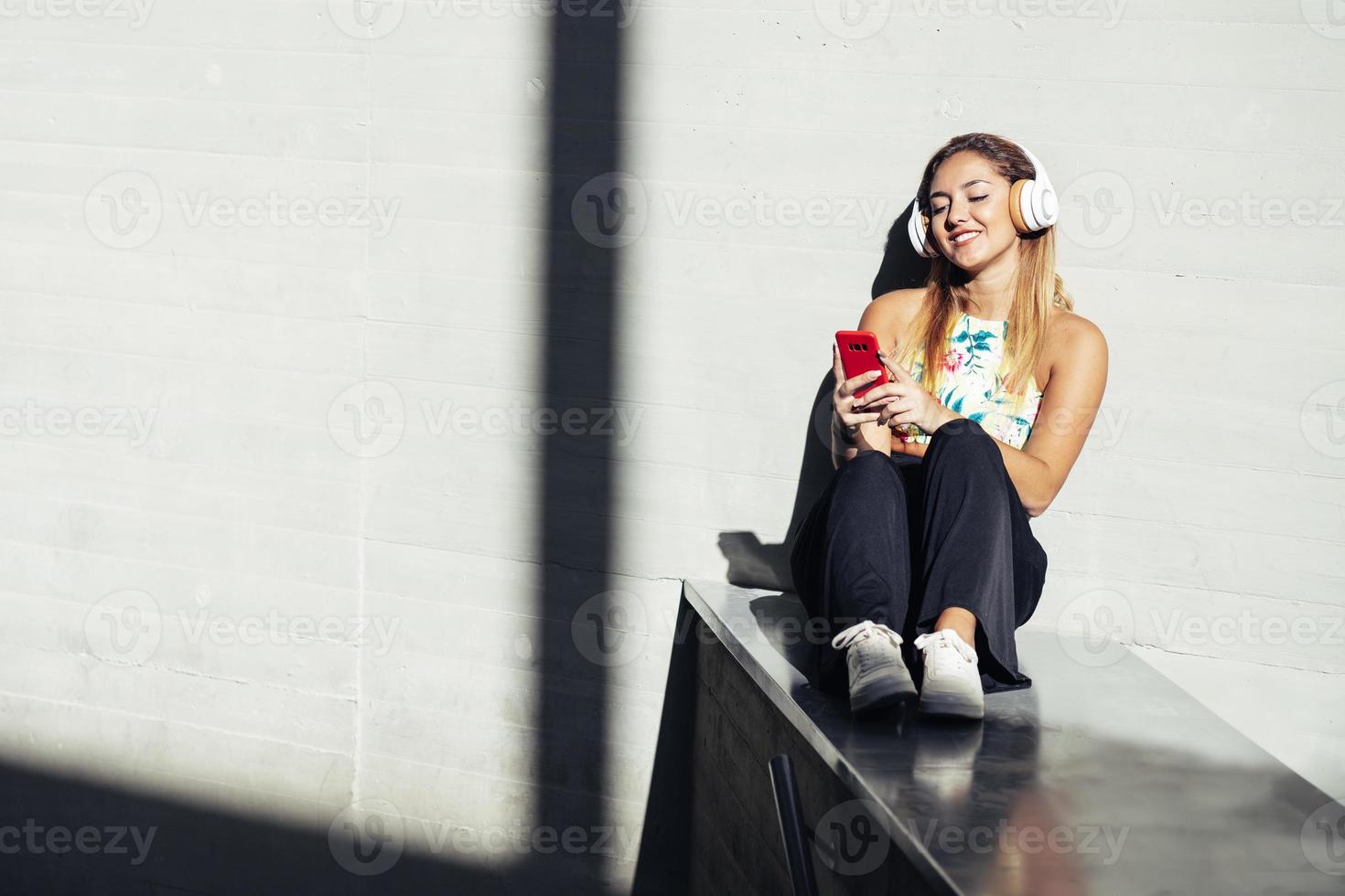 chica usando un teléfono inteligente con ropa casual foto