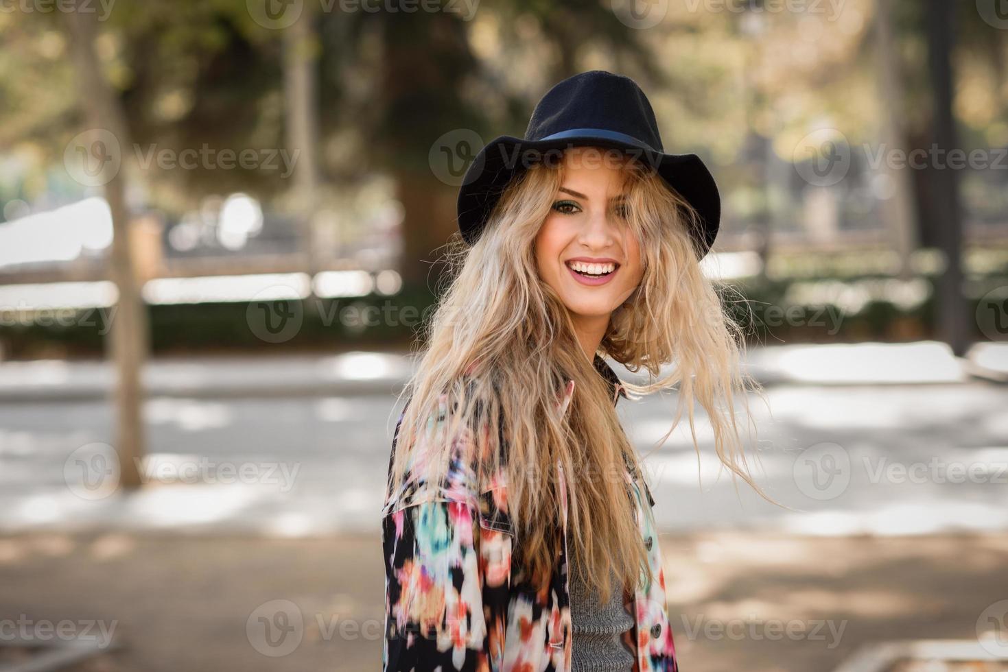 Woman looking at camera playing with her curly blonde hair photo