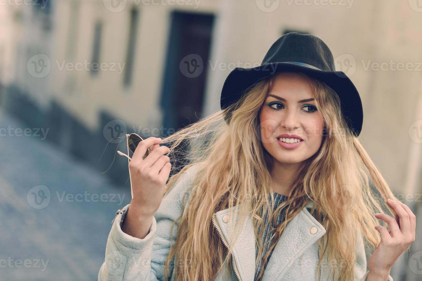 Mujer mirando con su cabello rubio rizado en el fondo urbano foto