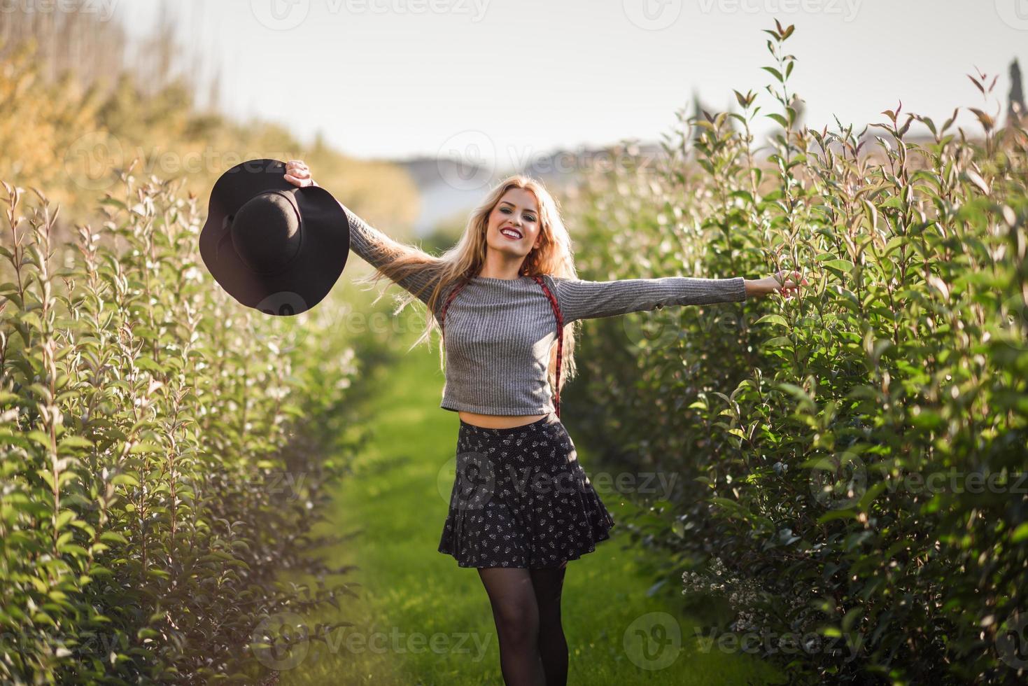 mujer joven rubia feliz en camino rural foto