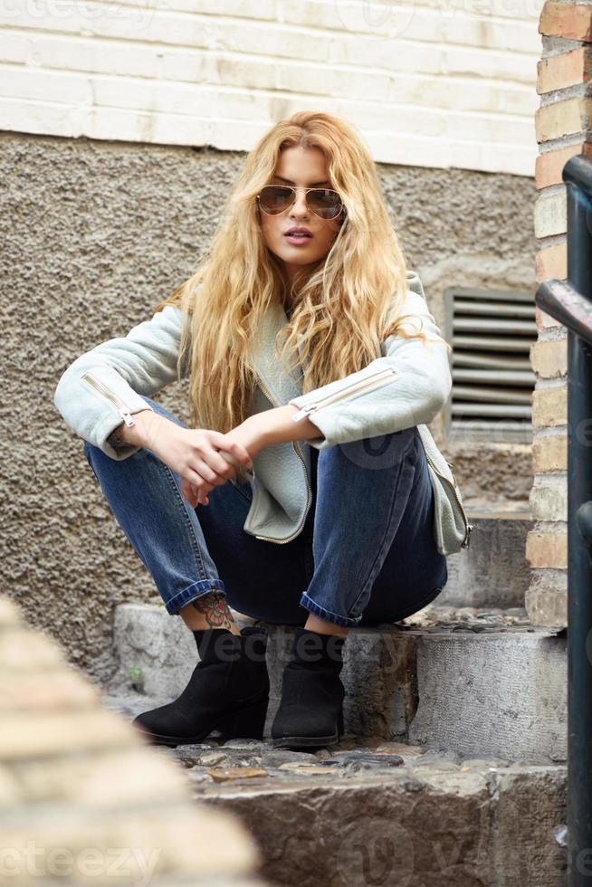 Hermosa mujer joven con cabello rizado con gafas de sol foto