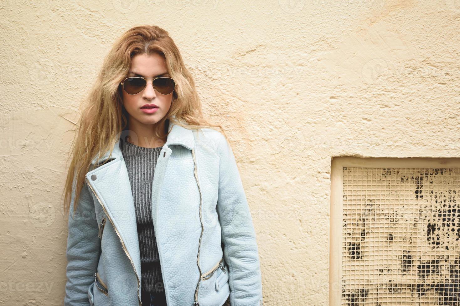 Beautiful young woman with curly hair wearing sunglasses photo