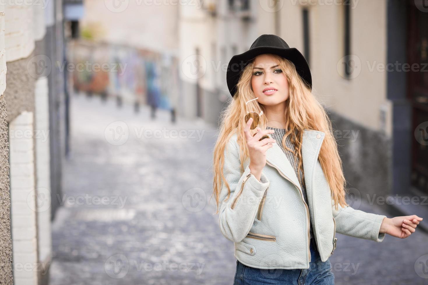 Beautiful young woman with curly hair wearing hat photo