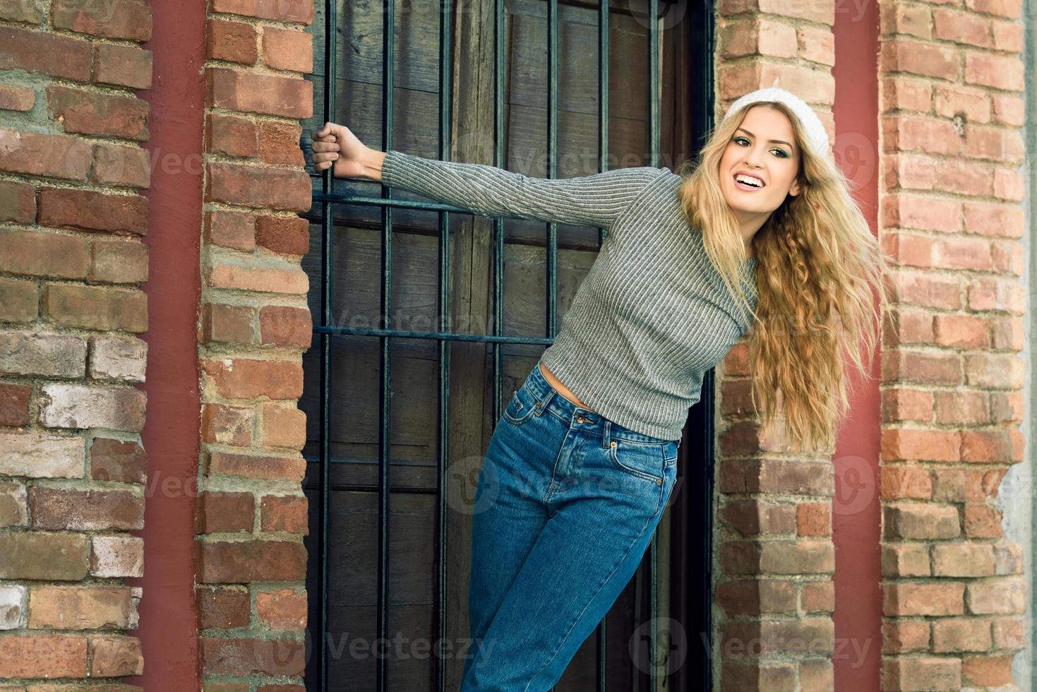 mujer joven, llevando, ropa casual, sonriente, en, urbano, plano de fondo foto