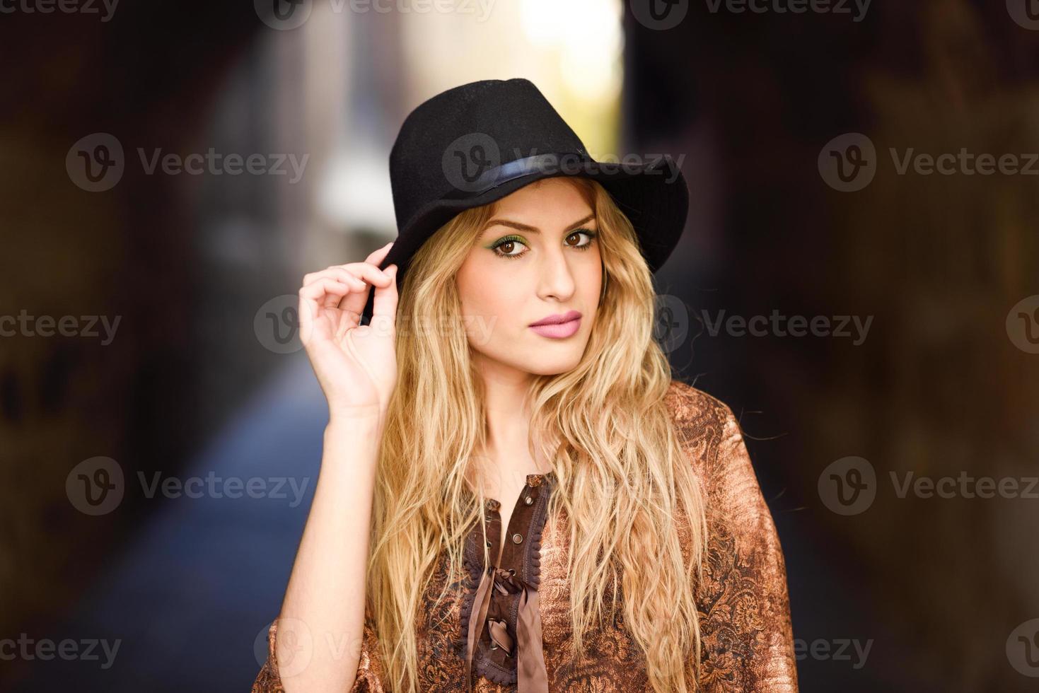 Beautiful young woman with curly hair wearing hat photo