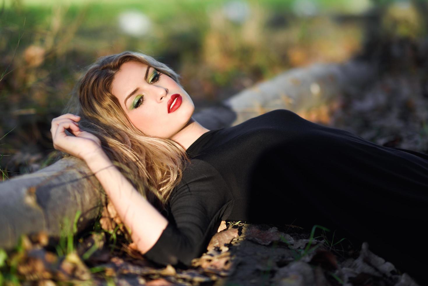 Relaxed girl lying on the field with long curly hair. photo