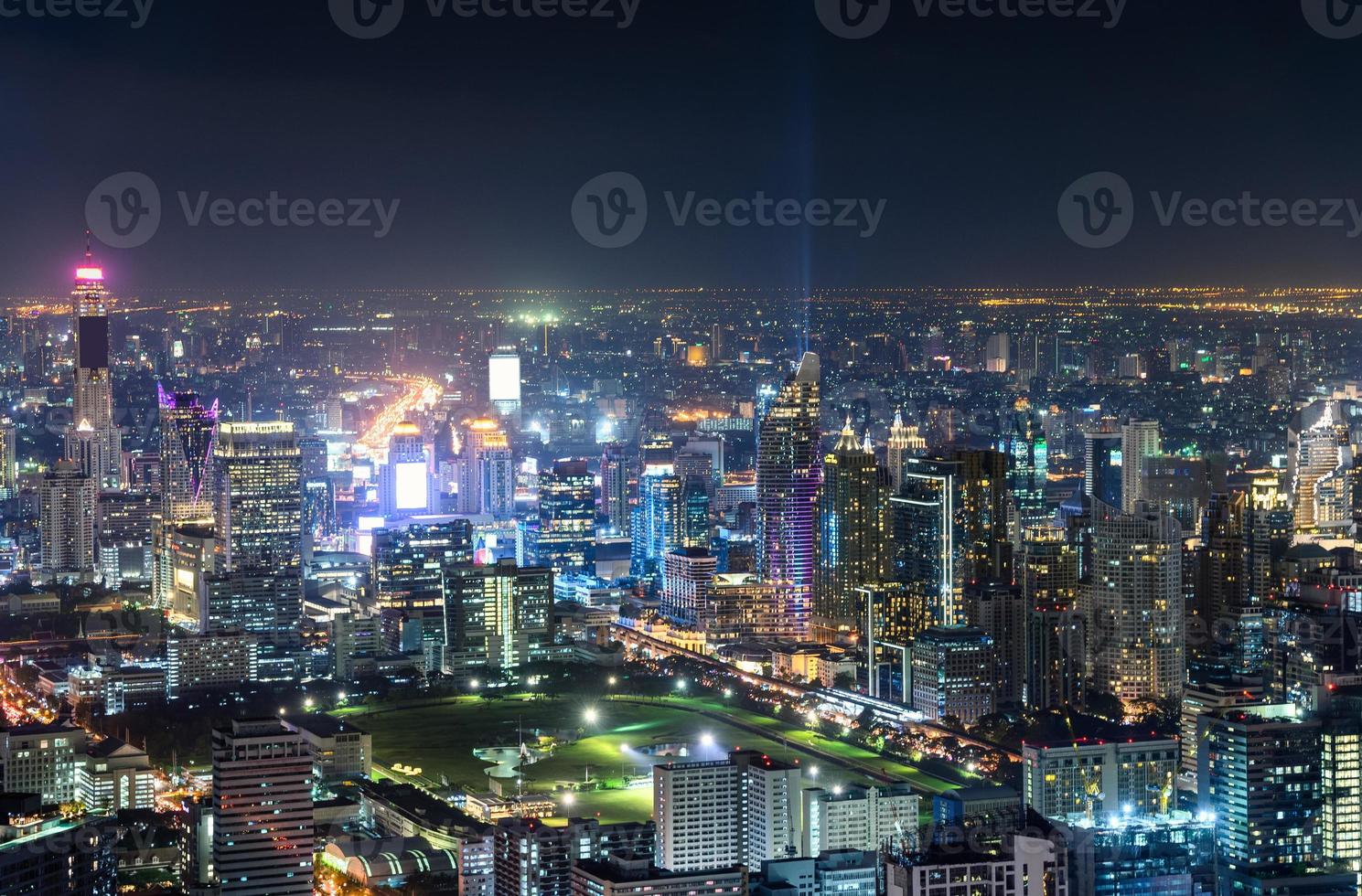 Cityscape with buildings crowded illumination with traffic light in Bangkok photo